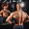 un-athlte-torse-nu-aux-muscles-toniques-pose-dans-la-salle-de-sport