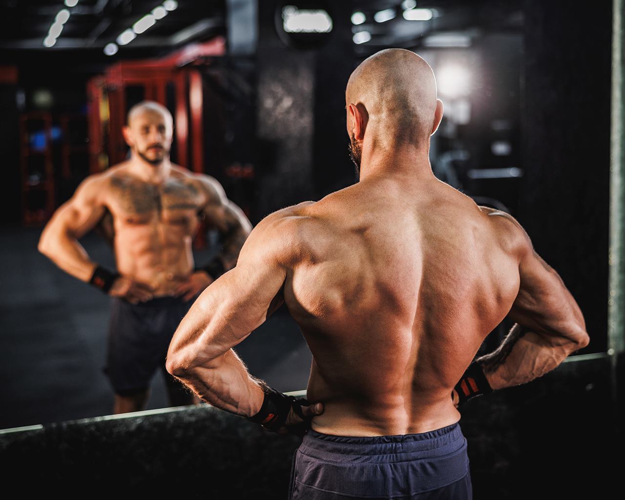 un-athlte-torse-nu-aux-muscles-toniques-pose-dans-la-salle-de-sport
